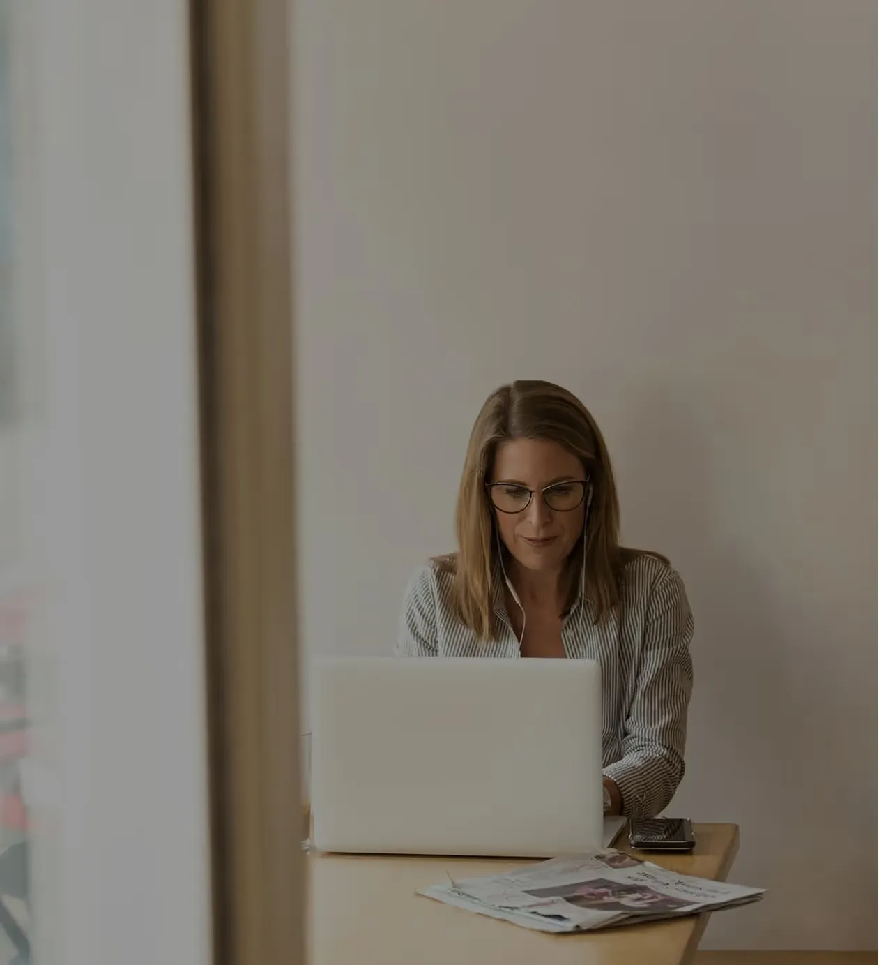 A hiring manager working on a laptop at a wooden desk.