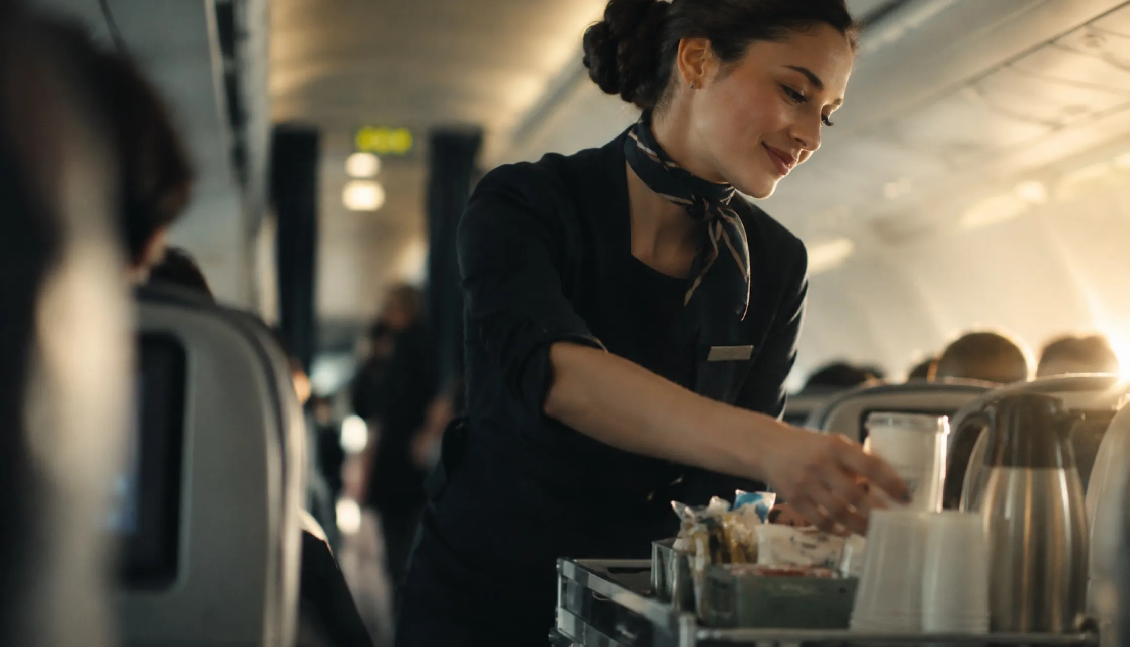 A cabin crew simulation: a flight attendant serving passengers in the cabin.